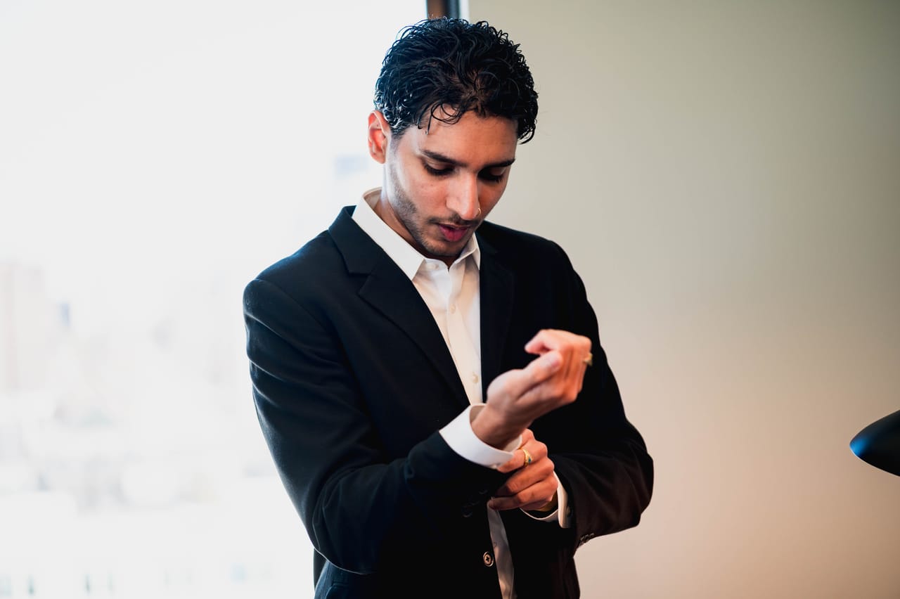 Abi adjusting a shirt cuff, photographed from the chest down